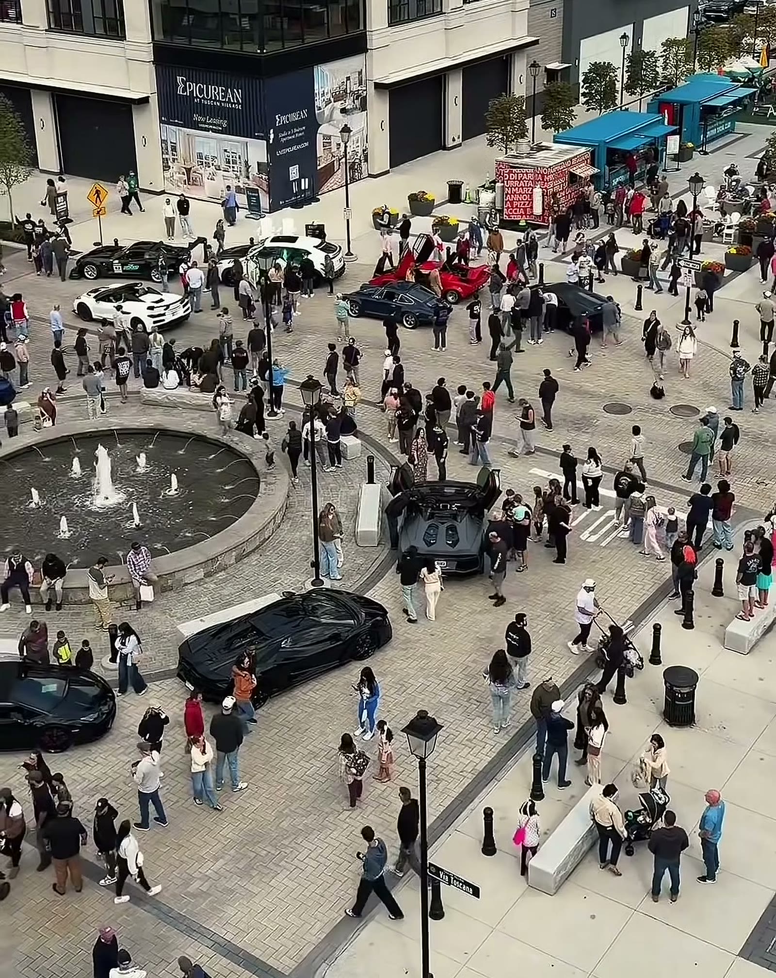 Crowds around the fountain on Via Toscana at Tuscan Village during the 2026 Concorso Italiano car show
